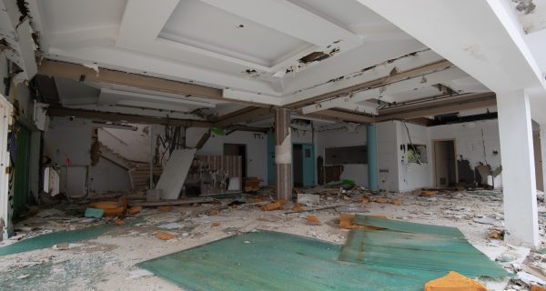 Interior of an old abandoned room with damaged furniture and a messy floor